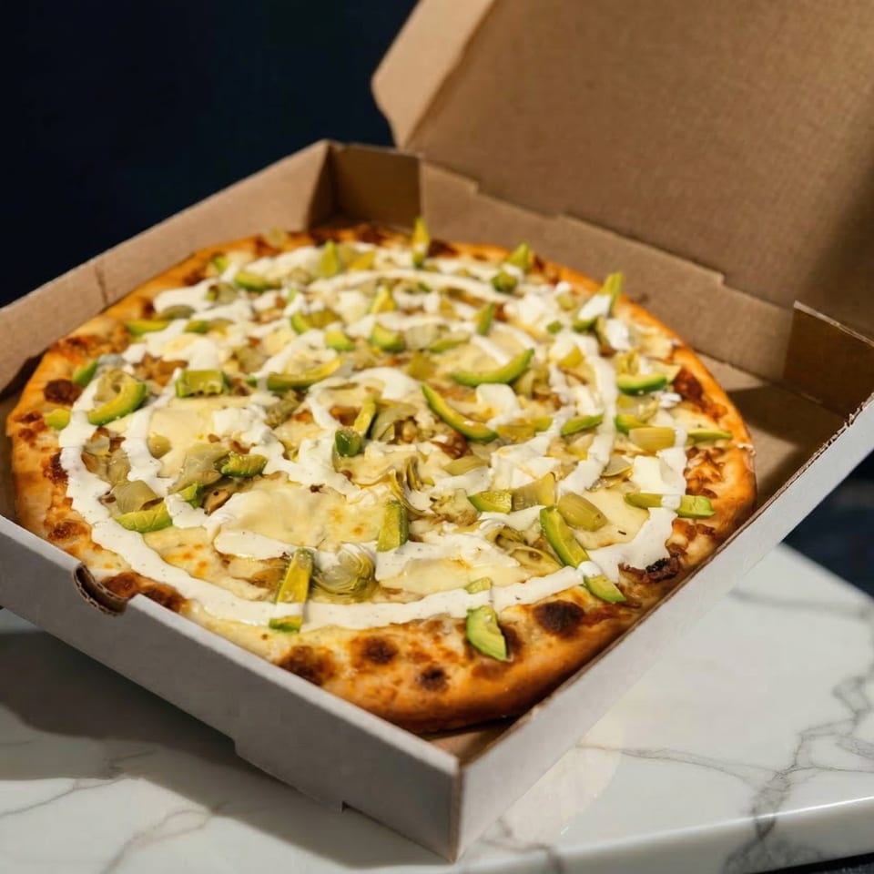 Ciro's Flying Pizza with white sauce, cheese, artichoke hearts, and avocado in a box.